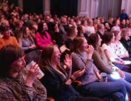 A crowd in a theatre laughing